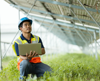 Construction worker with laptop looking at building