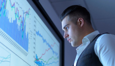 A man looking at a graph on a screen