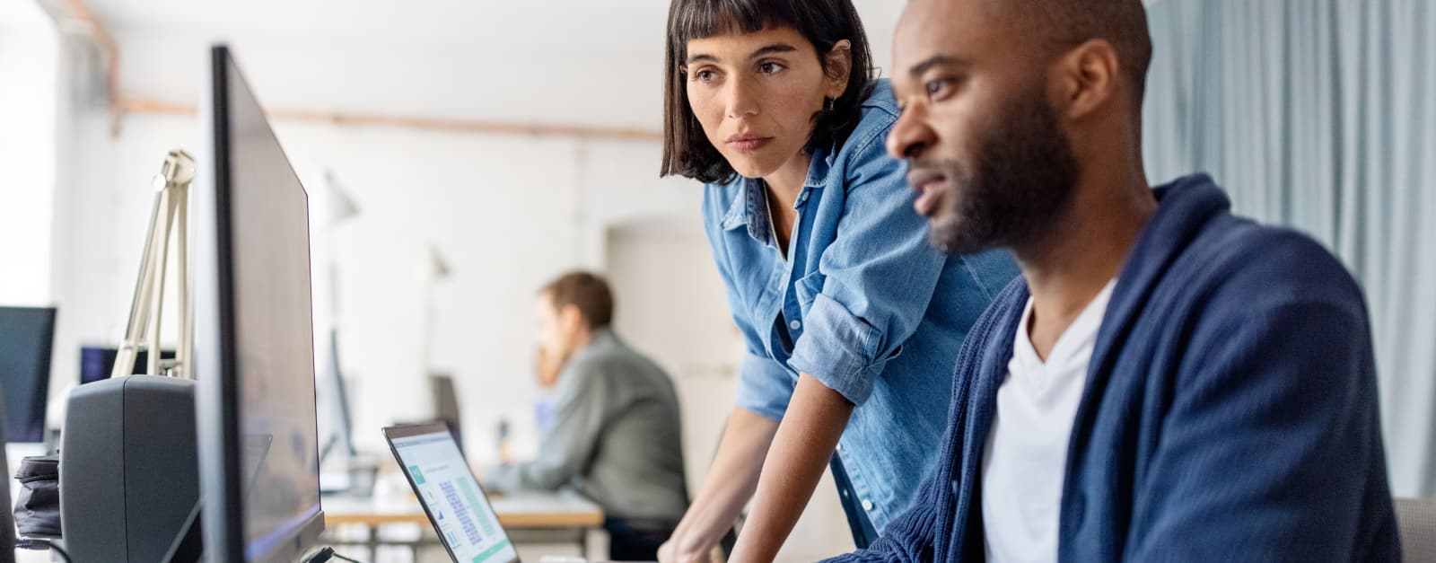 A man and woman working on a computer