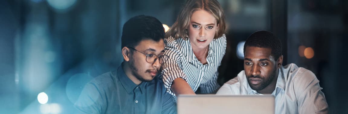 Three colleagues working together on laptop