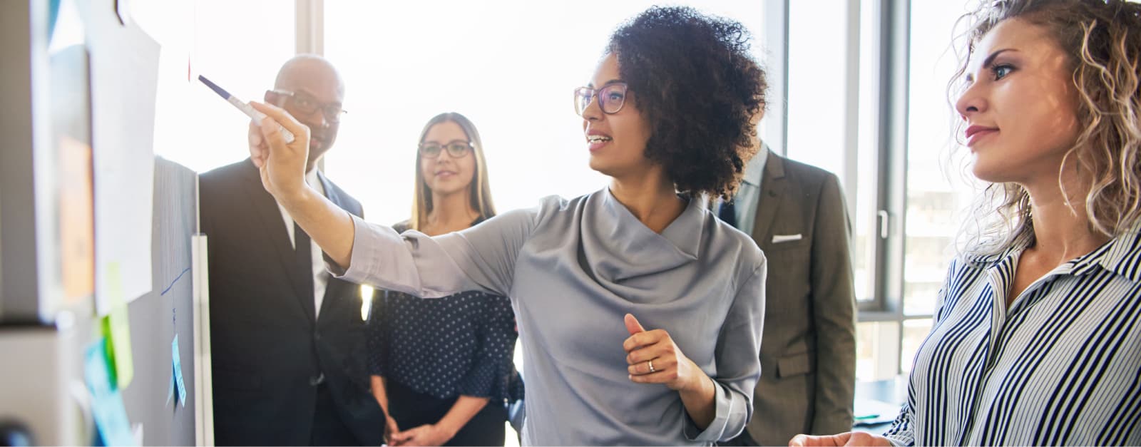 Woman showing board to colleagues