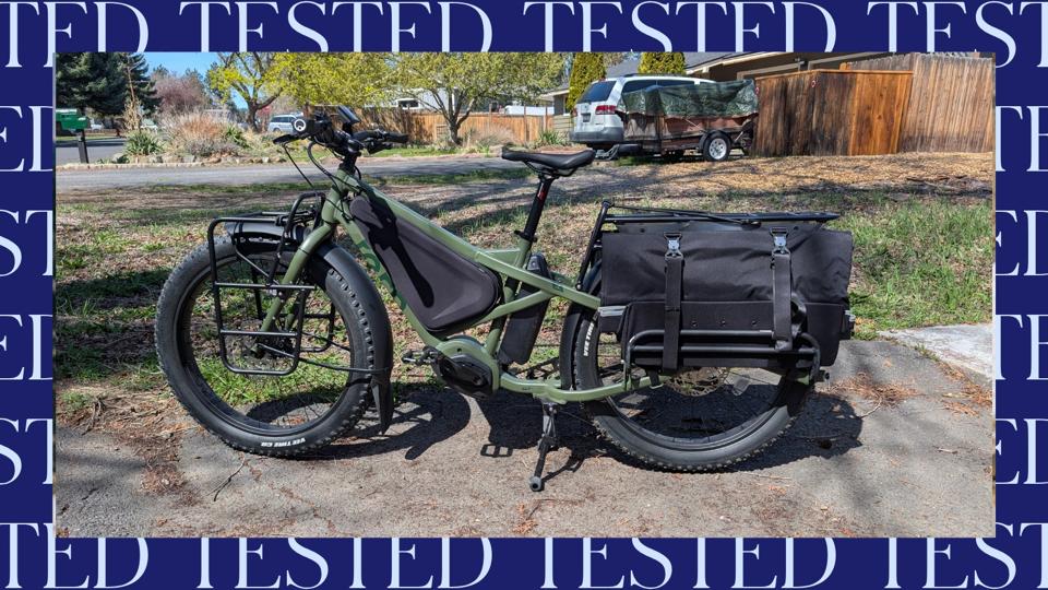 The Tern Orox Electric Cargo Bike in green photographed in a driveway on a sunny day