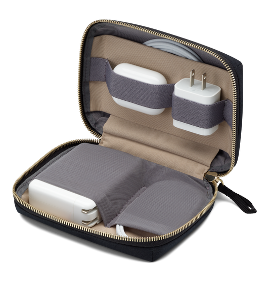 Bellroy Travel Organizer, unzipped and opened, with four elastic holders securing a small AC adapter, AirPods case, cable and large AC adapter