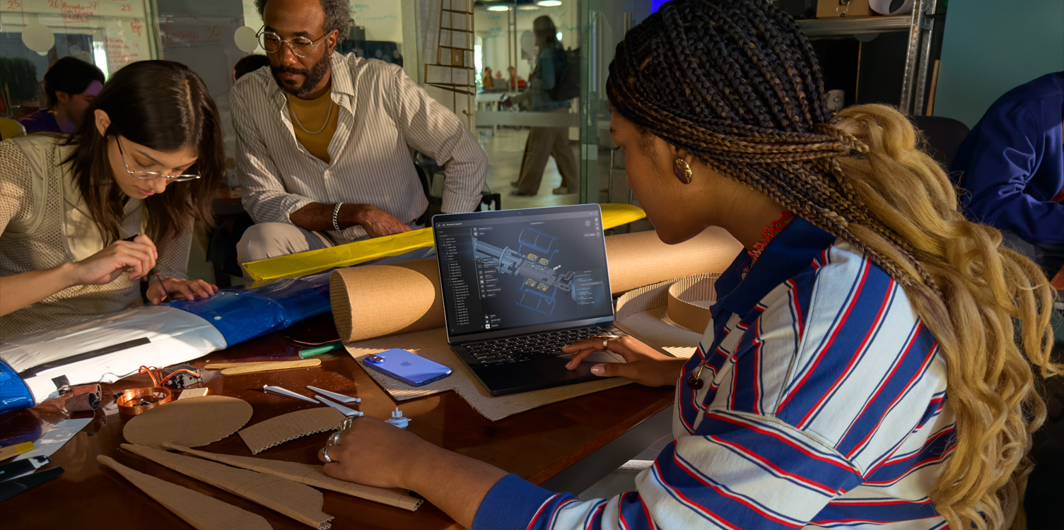 Een groep studenten zit aan een tafel en werkt aan een technisch project. Een van de studenten heeft een open MacBook voor zich met daarop de Shapr 3D-app.