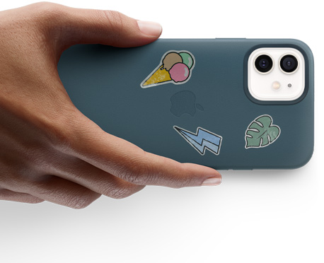 Main tenant un iPhone 12 avec des autocollants.