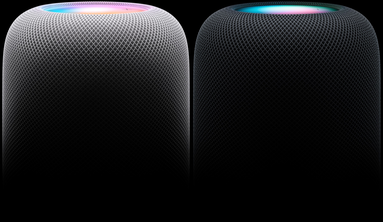 Två HomePod-högtalare bredvid varandra, sedda från sidan – den vänstra i vitt, den högra i midnatt
