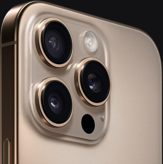 Vue rapprochée de l’arrière d’un iPhone 16 Pro titane sable montrant les caméras et le bouton latéral.
