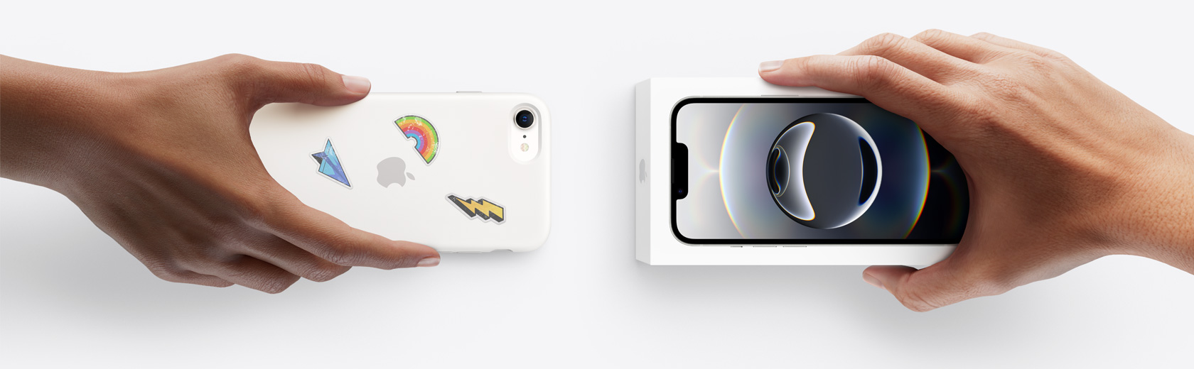 一隻手拿著用於換購的 iPhone,換取另一隻手中的盒裝 iPhone 16e。