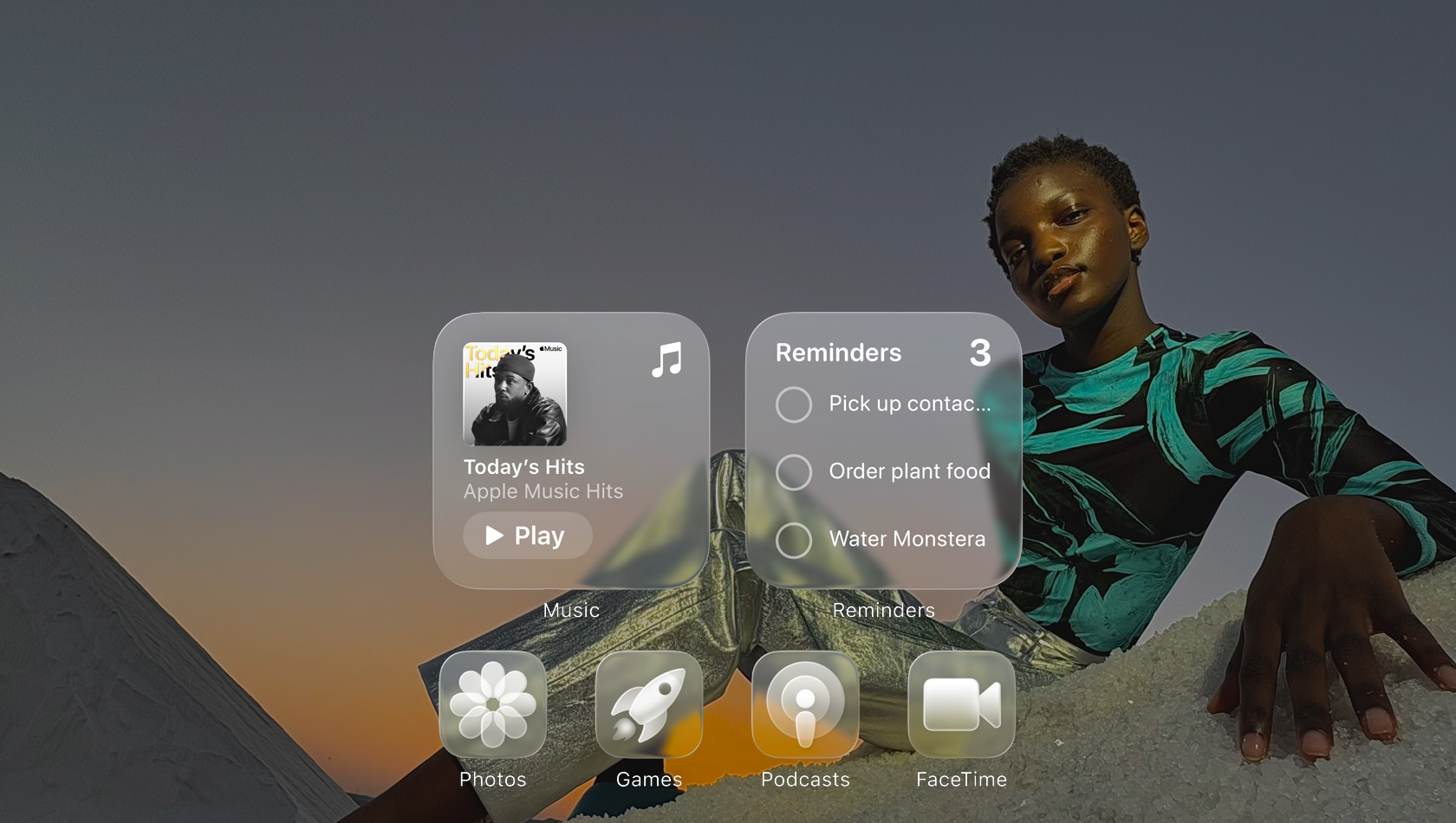 Affichage en Liquid Glass avec des icônes d’apps transparentes comme Musique, Rappels, Photos, Jeux, Balados et FaceTime avec un effet de réfraction sur le fond d’écran