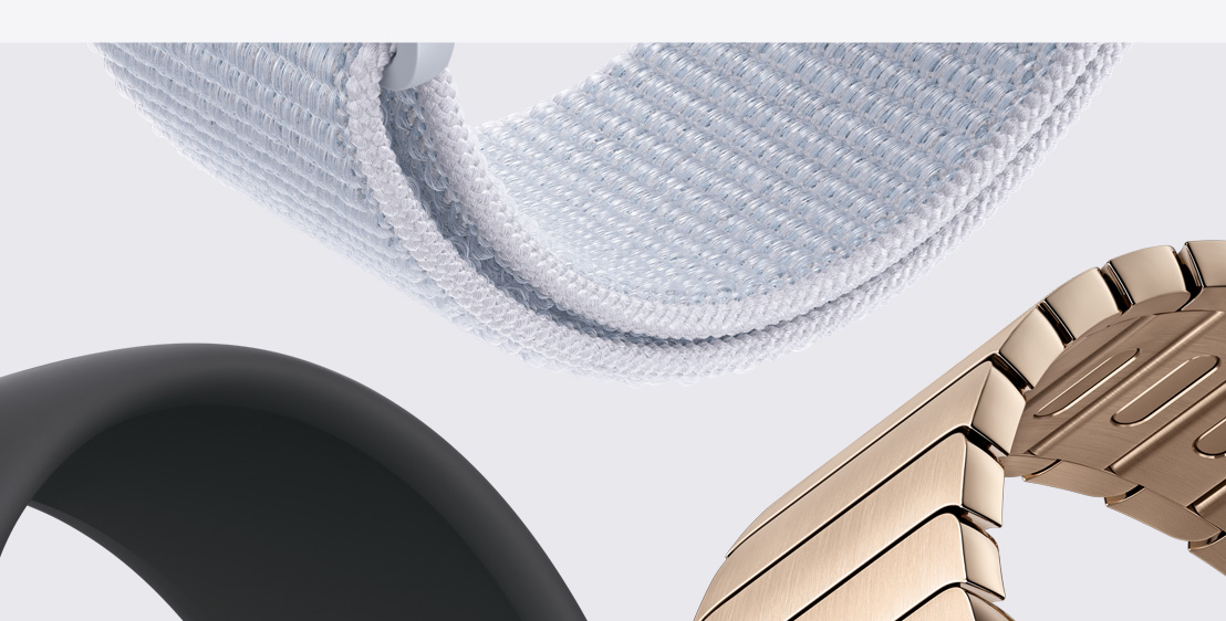 Tre Apple Watch-armband. En sportloop i dimblått. En sportloop i svart. Och ett länkarmband i guld.