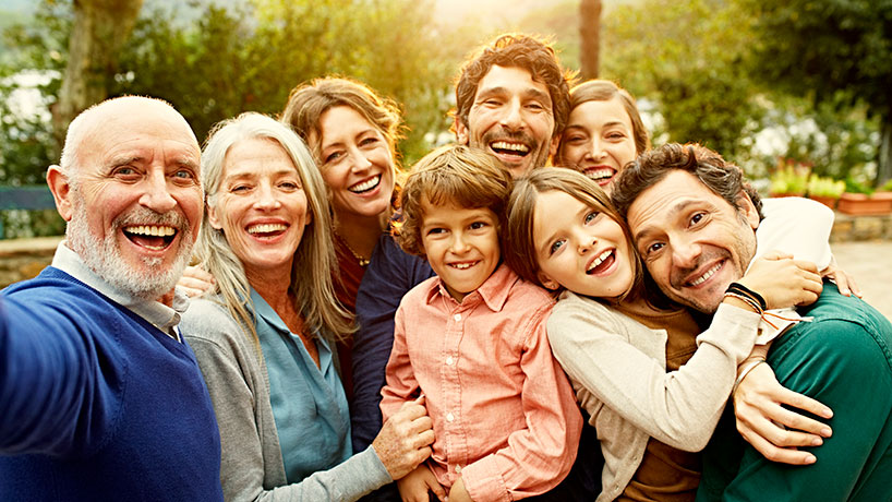 Group selfie of cheerful multi-generation family at yard