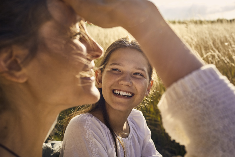 Mother and daughter sitting in a field.
