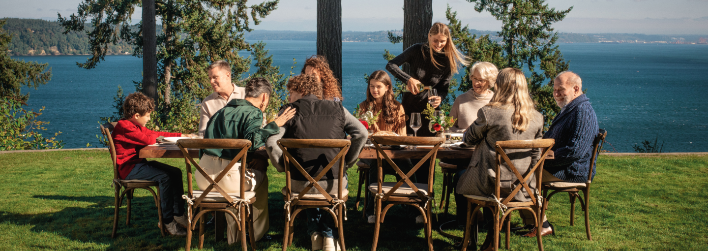 Multi-generational family eating a meal together outside